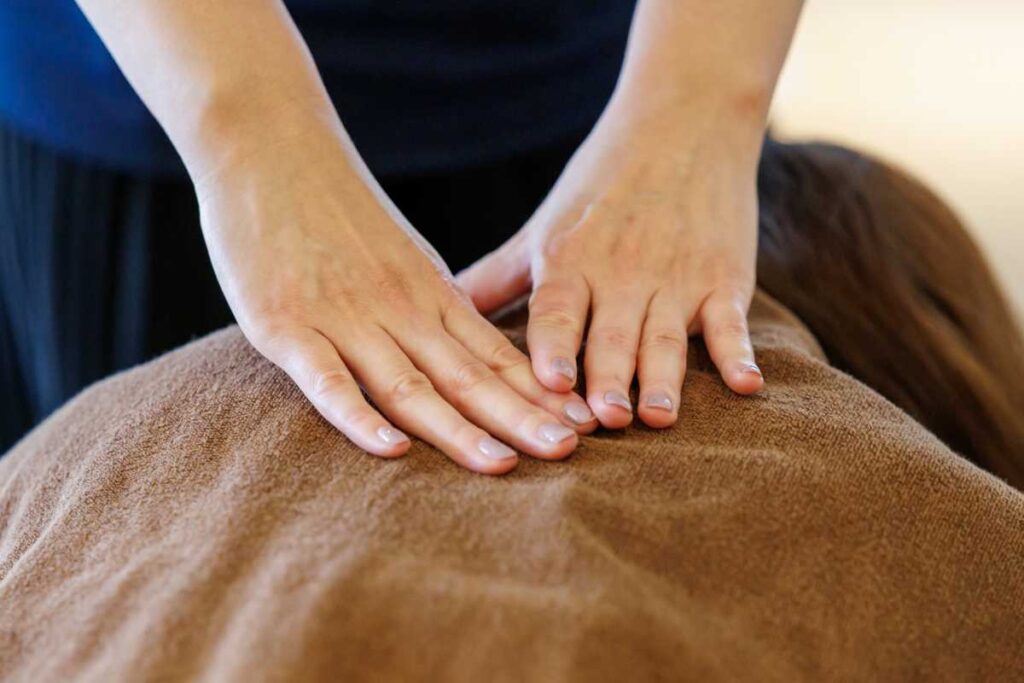 エステサロン開業に向けてマッサージを練習しているイメージ